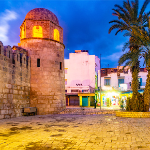 De-verlichte-Moskee-van-Sousse-in-de-avond-met-op-de-achtergrond-winkeltjes