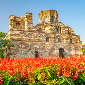 Een kerk in Nessebar met rode bloemen