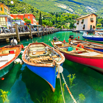 Zomerlandschap met houten boten Gardameer, Torbole stad, Italië 
