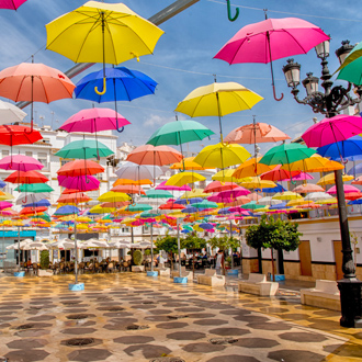 foto van vele kleurrijke paraplus hangend in de lucht op een plein in Torrox Spanje