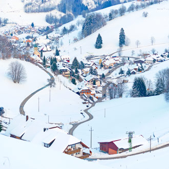 Sneeuw in een vallei met huizen Schwarzwald