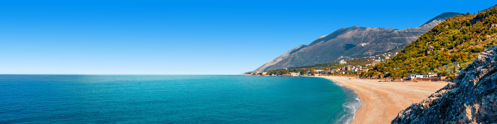 Uitzicht over turqoise helderblauwe zee met strand in Albanië