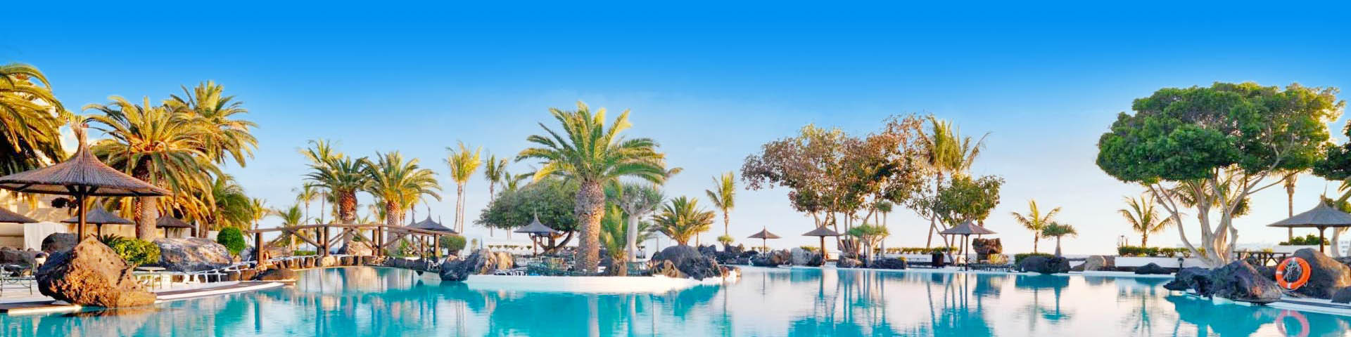 Prachtig Zwembad met wuivende palmboemen aan de de Canarische Eilanden 