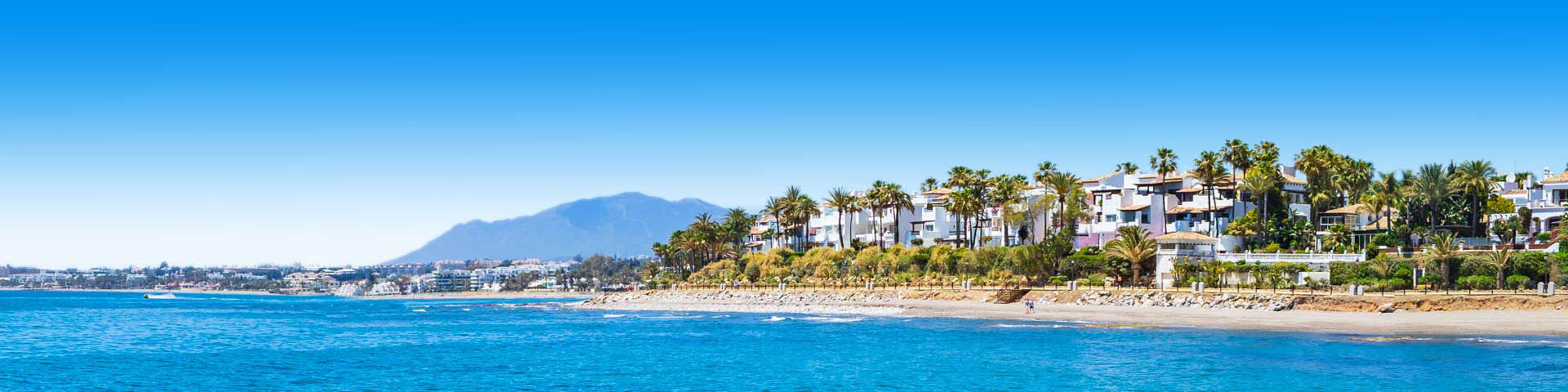 Uitzicht op het mooie strand van Marbella met ligbedjes en parasols