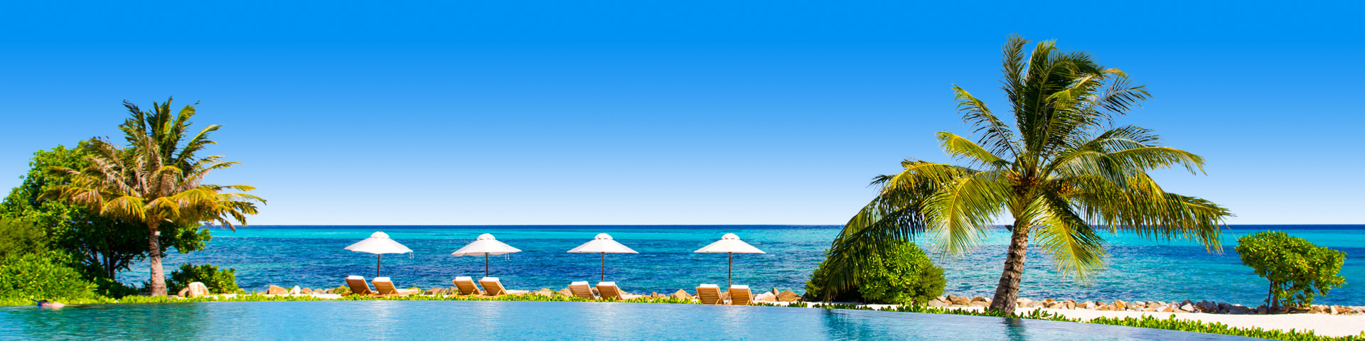 Relaxen op een ligbedje aan het zwembad van een all inclusive hotel aan het strand