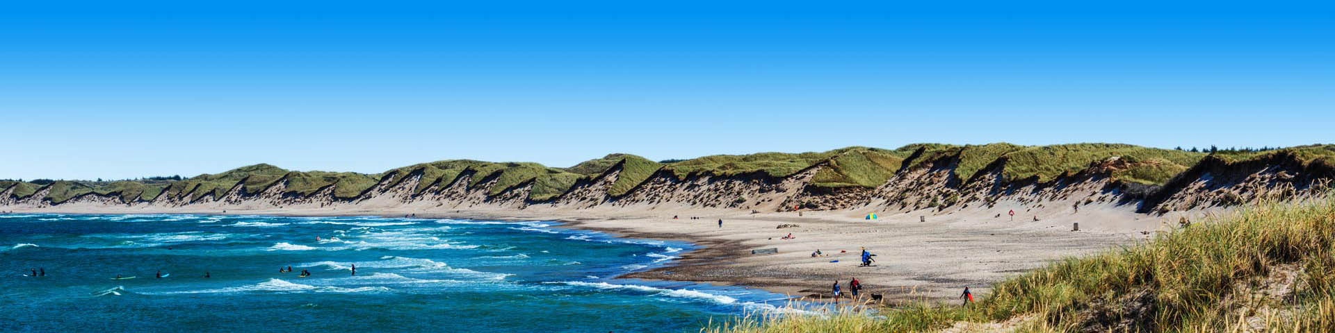 Deens landschap met blauw water en groene duinen
