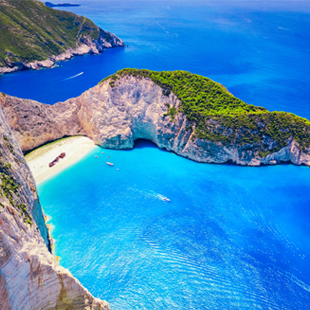 Shipwreck Beach op Zakynthos, een afgelegen zandstrand met felblauw water, omringd door hoge kliffen en een scheepswrak.