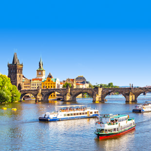 Uitzicht op de Karelsbrug over de Moldau in Praag met boten op het water.