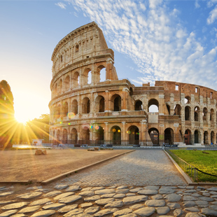 Het Colosseum in Rome met de iconische boogstructuren, deels verlicht door zonlicht, en een open plein op de voorgrond.