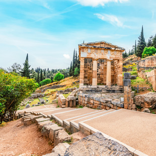 Griekse ruïnes in Delphi met een goed bewaard tempelgebouw en stenen zuilen, gelegen op een heuvel met uitzicht op groene valleien