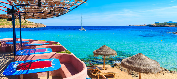 Uitzicht op helderblauwe zee met parasols op Ibiza