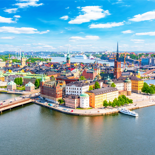 Gamla Stan in Stockholm met smalle straat, kleurrijke historische gebouwen en geplaveide straat onder een heldere lucht.