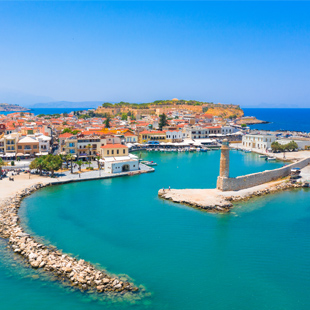 De haven van Rethymnon op Kreta, met een vuurtoren en huisjes met oranjerode daken