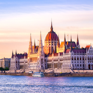 Het Hongaarse parlement in Boedapest langs de Donau, met indrukwekkende neogotische gevel, torens en een brug over de rivier.