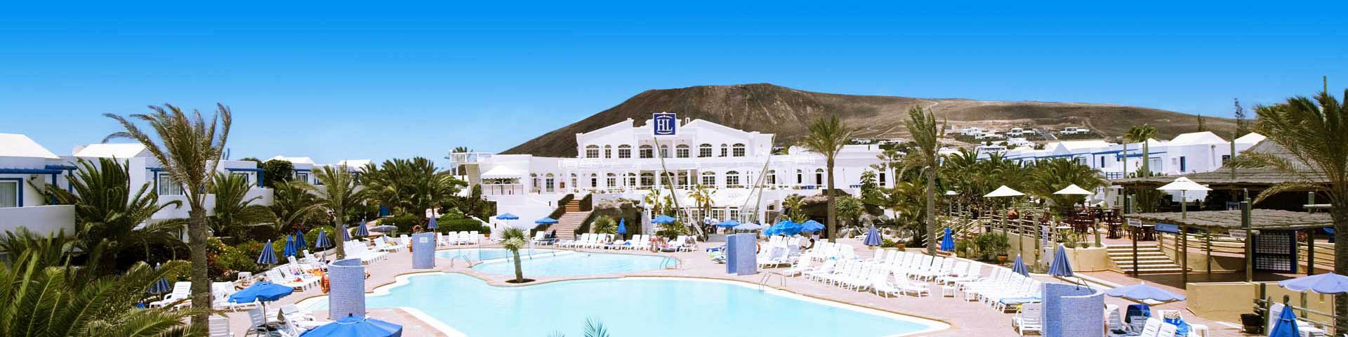 Hotelgebouw van hotelketen HL met uitzicht op het zwembad en een berg
