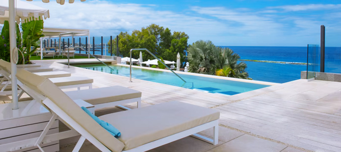 Loungebed met wapperende gordijnen op het strand