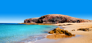 Helderblauwe zee met strand op Lanzarote