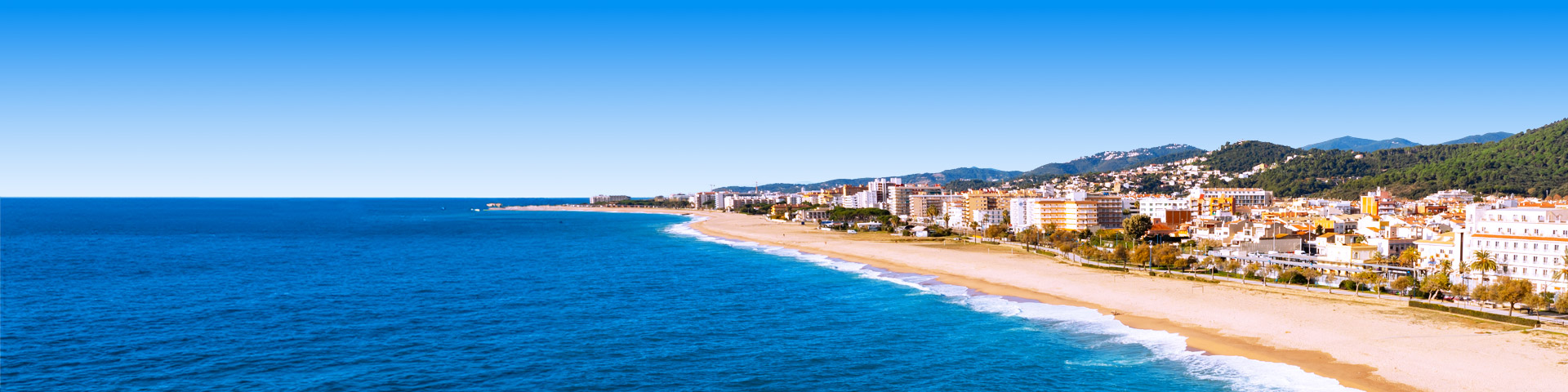 Kustlijn met strand, hotels en groene heuvels bij Malgrat de Mar