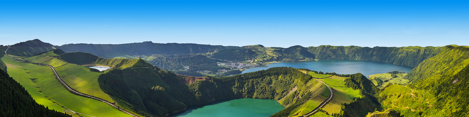 Heuvels met een meer en een dorp in de verte Azoren