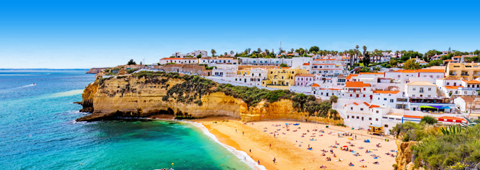Typisch sfeerbeeld van de Algarve: een wit dorpje op een klif bij het strand