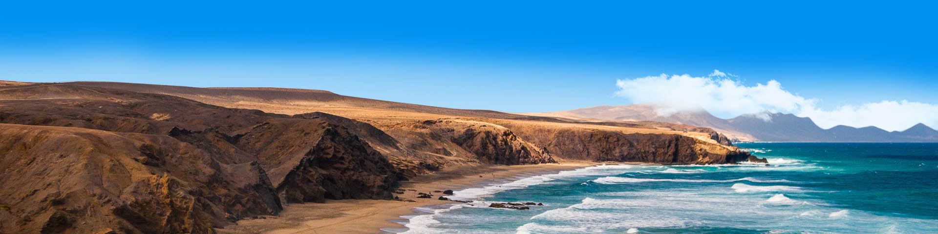 De kustlijn van Fuerteventura met de zee en het landschap op de achtergrond