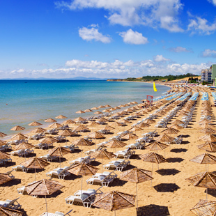 Een breed zandstrand met ligstoelen in Bulgarije